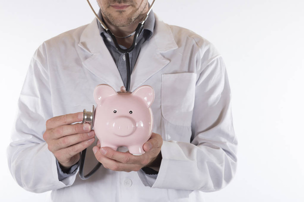Doctor with stethoscope on piggy bank - Foto, immagini
