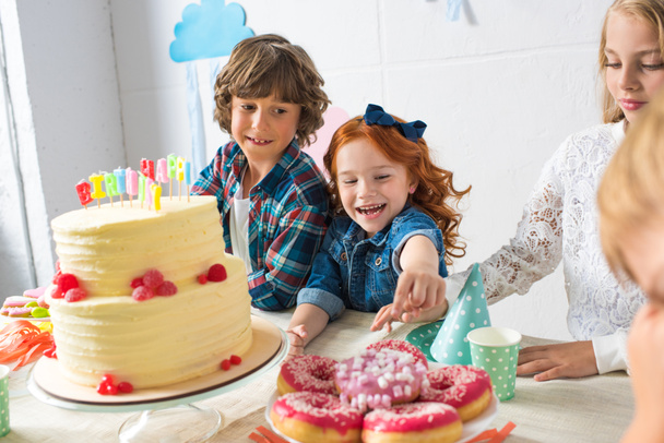 lapset syövät makeisia syntymäpäiväpöydässä
  - Valokuva, kuva