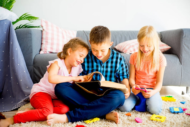 Three siblings reading a book - Foto, immagini