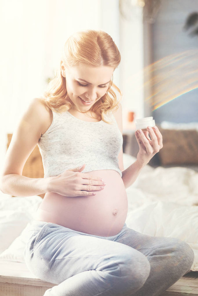  pregnant woman applying boy cream  - Φωτογραφία, εικόνα