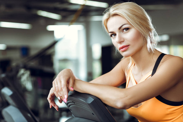 Beautiful tired blond woman on treadmill in gym after workout. - Fotografie, Obrázek