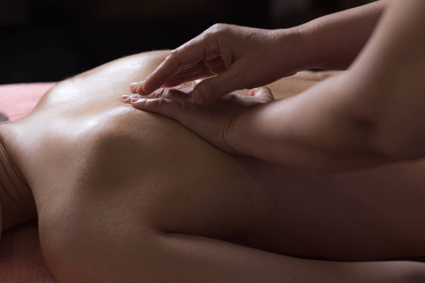primer plano masajista manos haciendo girar masaje. foto low key
 - Foto, Imagen