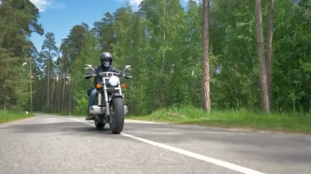 Motorradfahrer mit Totenkopf fährt auf sonniger Straße. - Filmmaterial, Video