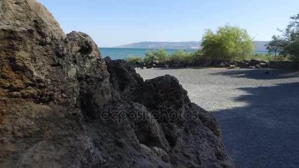 Lento salire e scendere sul masso sulla riva del mare di Galilea in Israele
  - Filmati, video