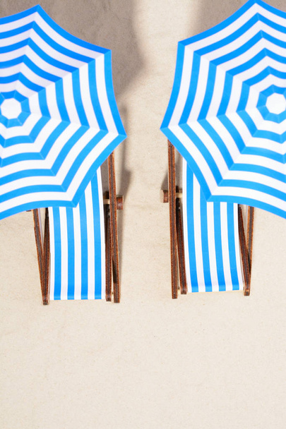 Muebles de playa bajo sombrillas
 - Foto, Imagen