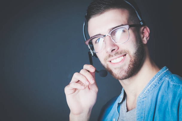 Portrait of young male with microphone. Call-center assistant. Help desk worker. - Fotó, kép