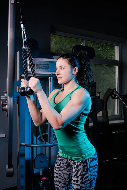 Entrenamiento de mujer fitness sexy joven con máquina de entrenamiento en el gimnasio
 - Foto, Imagen