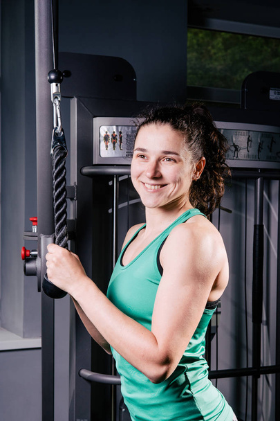 Entrenamiento de mujer fitness sexy joven con máquina de entrenamiento en el gimnasio
 - Foto, imagen