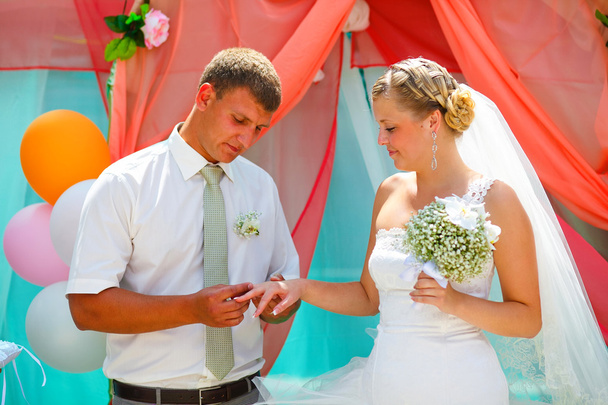 新郎の結婚式のカップルの新婚夫婦 registr でリング花嫁を着ています。 - 写真・画像