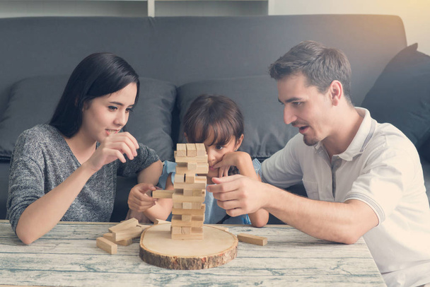 famiglia felice e figlia che gioca la torre di blocchi di legno a hom
 - Foto, immagini