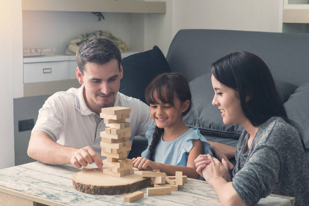 happy family and Daughter playing the wooden blocks tower at hom - Foto, imagen