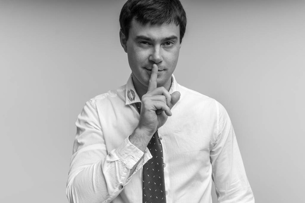 Привабливий чоловік з пальцем на губах і помадою на комірі сорочки
 - Фото, зображення