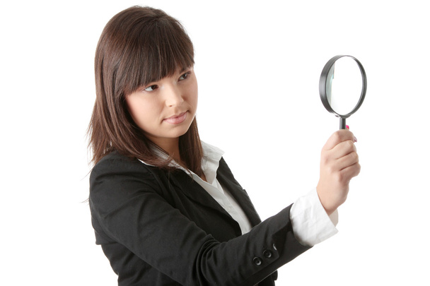 Woman looking into a magniying glass - Foto, afbeelding