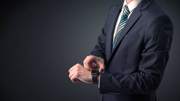 Man in suit wearing smartwatch. - Фото, изображение