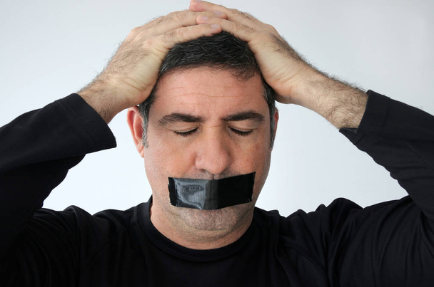 Hombre con los ojos cerrados y la boca cubierta con cinta adhesiva
 - Foto, Imagen