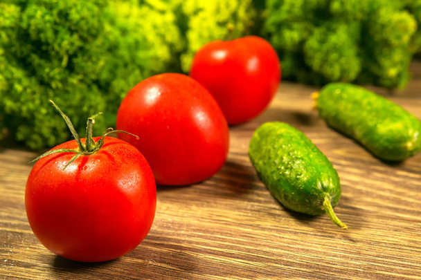 Fresh vegetables. Tomatoes and cucumbers on a wooden table - Foto, Imagen