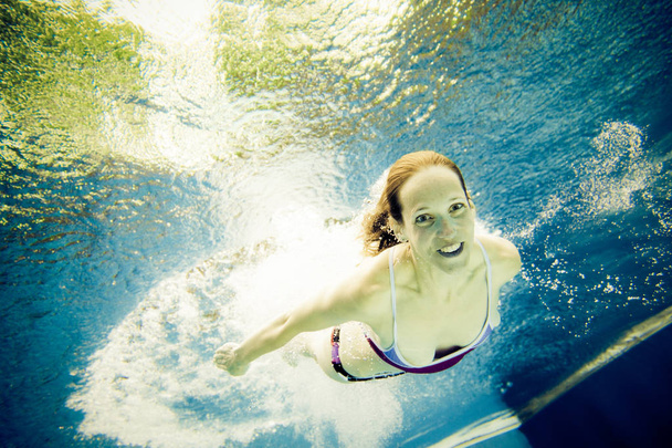 Underwater View Of A Young Woman Jumping Into The Water - Фото, зображення