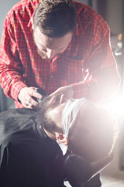 Barbier faire coupe de barbe à l'aide de rasoir
 - Photo, image