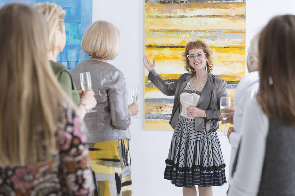 Artist presenting her painting - Zdjęcie, obraz