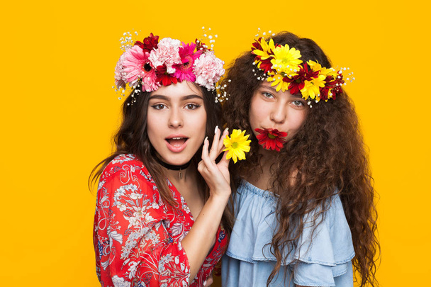Two smiling girls posing with flowers - Foto, imagen