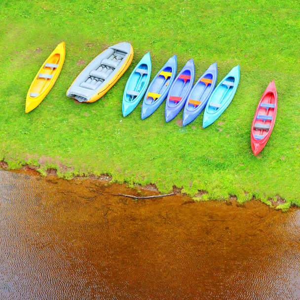 Kanus und Floß auf einem Seeufer. Luftaufnahme des Platzes für Freizeitaktivitäten. Glückliche Ferien in der Wildnis. - Foto, Bild