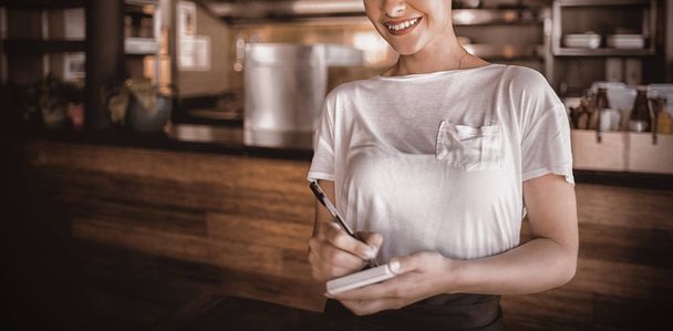 Smiling waitress standing in restaurant - Zdjęcie, obraz