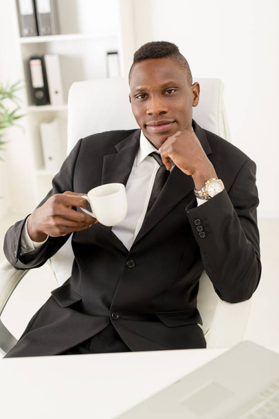 африканський бізнесмен сидить в офісі
 - Фото, зображення