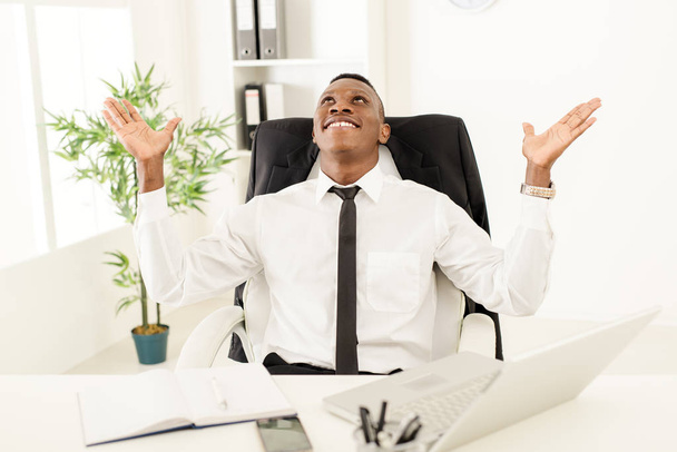 Африканский бизнесмен празднует успех в офисе
 - Фото, изображение