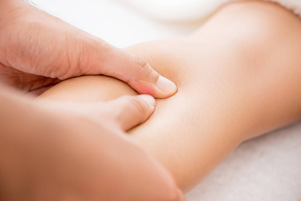 Mains de thérapeute masculin donnant massage des jambes à une femme dans le spa
 - Photo, image