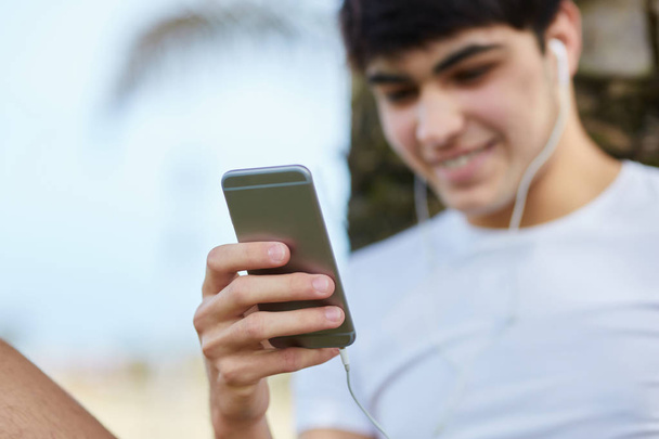 Jeune homme heureux écoutant de la musique depuis un smartphone
 - Photo, image