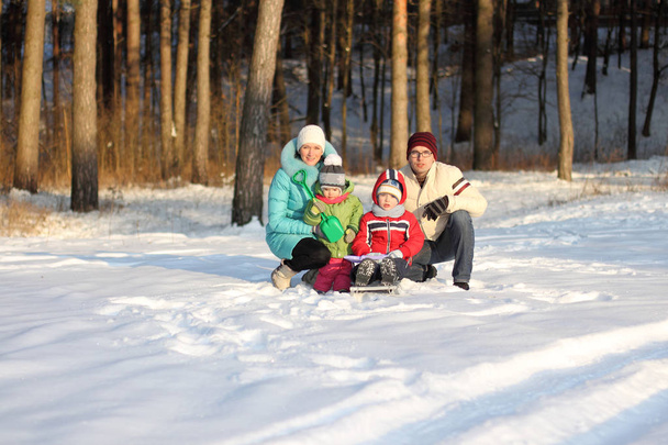 familie van vier heeft pret in de sneeuw in de winter - Foto, afbeelding