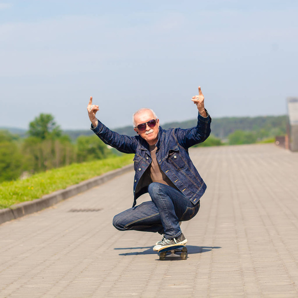 スケート ボードに乗って楽しんでエネルギッシュなシニア男性 - 写真・画像