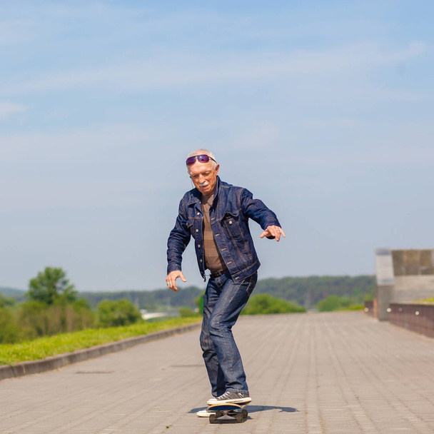 energetic senior man enjoying riding a skateboard - Foto, Imagem