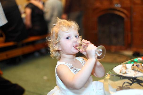 Menina pequena criança loira come com gosto
 - Foto, Imagem