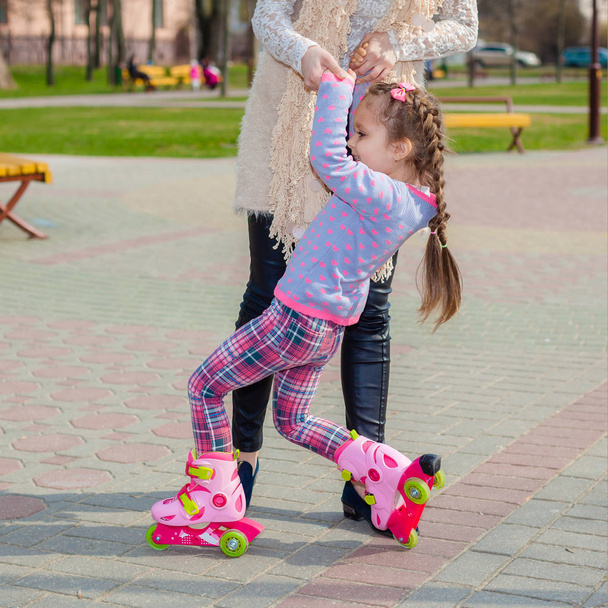 Mamá y su hija montan en patines
 - Foto, imagen