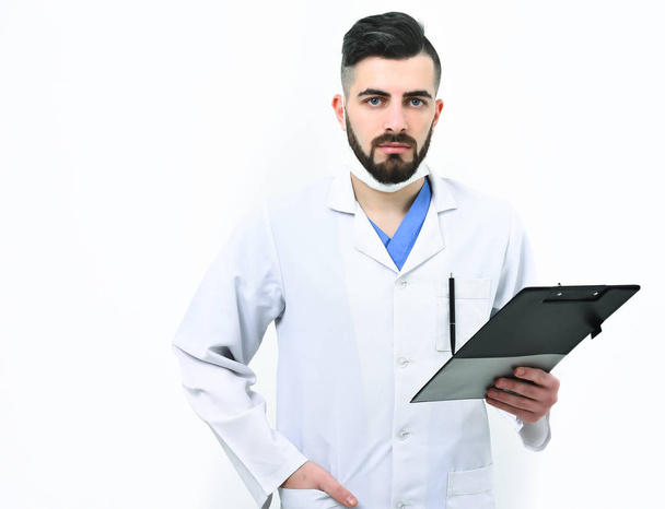 Doctor with beard holds clip folder for prescriptions. - Zdjęcie, obraz