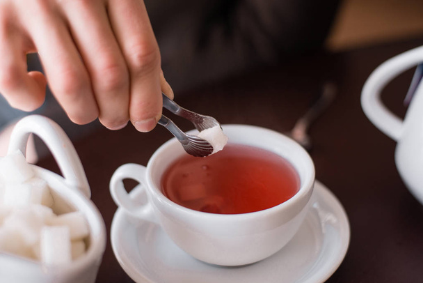 ζάχαρη είναι ρίχνονται σε τσάι - Φωτογραφία, εικόνα