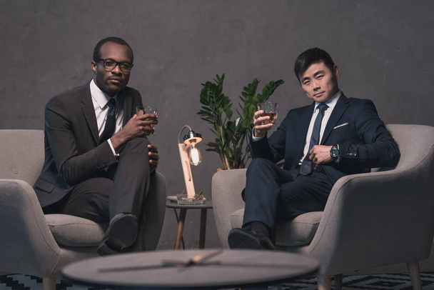 hommes d'affaires multiéthiques se détendre sur des fauteuils
 - Photo, image