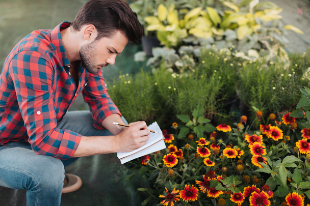 jardinero haciendo notas en cuaderno
 - Foto, imagen