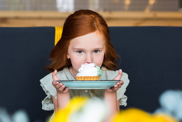 girl eating cupcake in cafe - Photo, Image