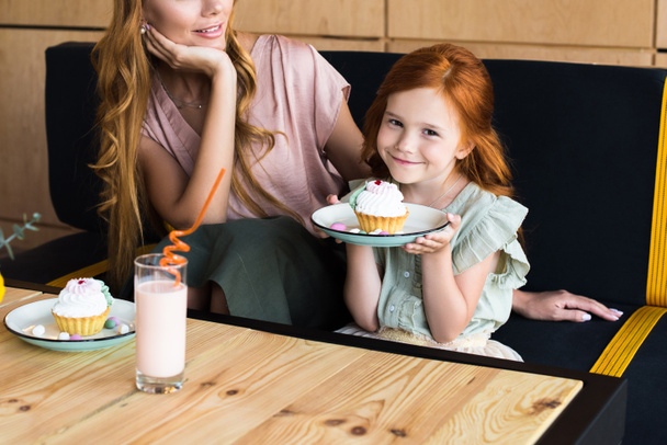 mother and daughter eating cupcakes - Foto, Imagen