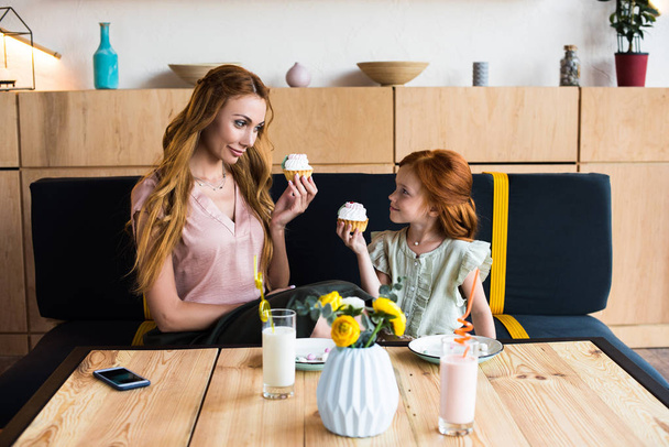 mother and daughter eating cupcakes - Photo, Image