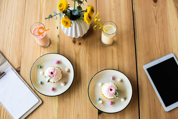ミルクセーキとテーブルの上のカップケーキ - 写真・画像