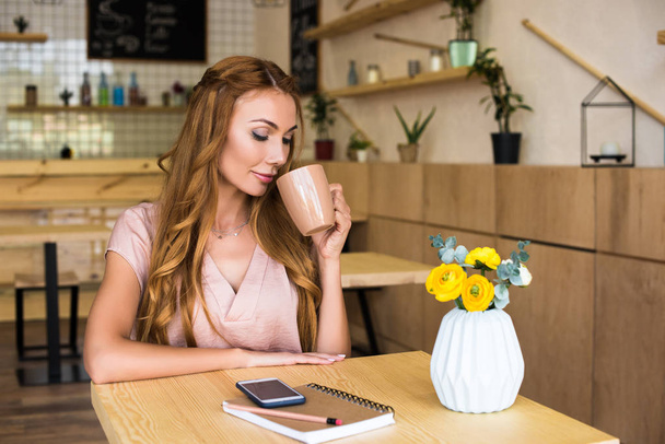 женщина пьет кофе в кафе - Фото, изображение