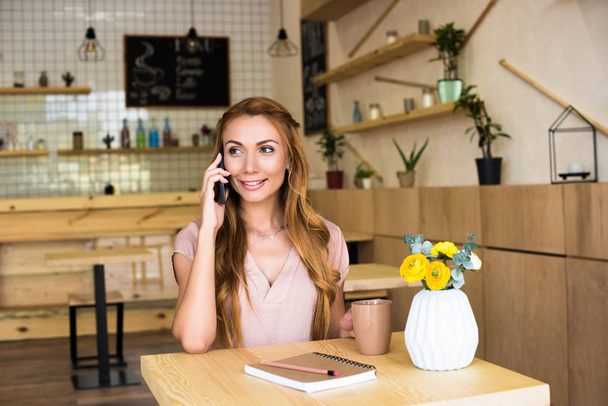 woman using smartphone in cafe - Zdjęcie, obraz