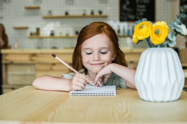 Menina desenho à mesa no café
  - Foto, Imagem