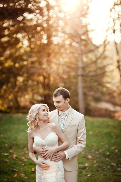 Coppia di sposi in abiti bianchi per una passeggiata nel parco
 - Foto, immagini