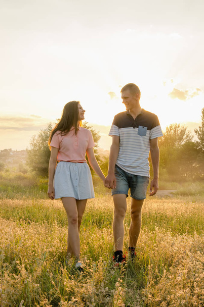 nuori rakastava pari kävelee kentällä
 - Valokuva, kuva