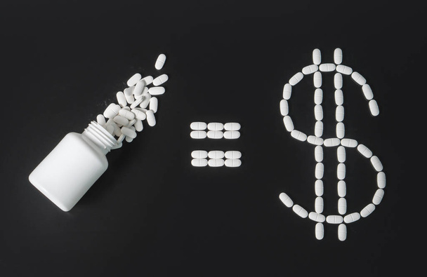 Making money in pharmaceutical industry or high medical expenses. Pill bottle equals dollar sign written with pills.  - Photo, Image