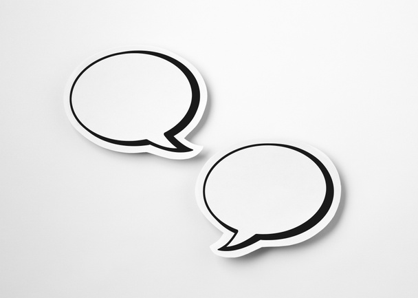 2 blank speech bubbles on white paper background. Chat bubble cut from cardboard. Simple and effective design.  - Photo, image